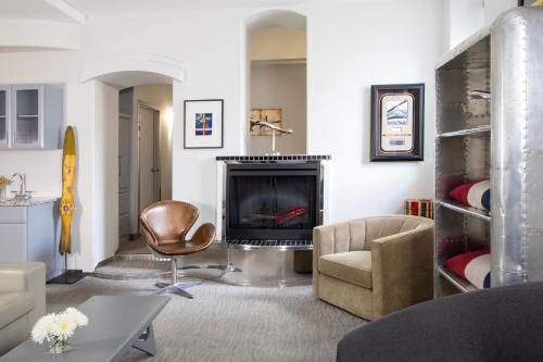 a living room with a chair and a fireplace at Retro Suites Hotel in Chatham