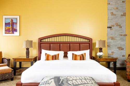 a bedroom with a large bed with two tables and two lamps at Retro Suites Hotel in Chatham