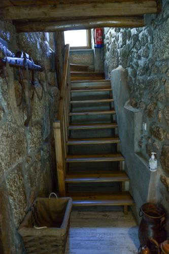 a staircase in a room with a stone wall at Casa do Ti Gabriel in Sabugueiro