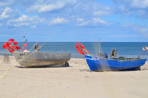two boats sitting on the sand on the beach at Villa Stoertebeker Apartment 19 in Baabe