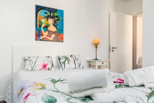 sypialnia z łóżkiem z obrazem na ścianie w obiekcie Tilias Apartment at Estoril w mieście Estoril