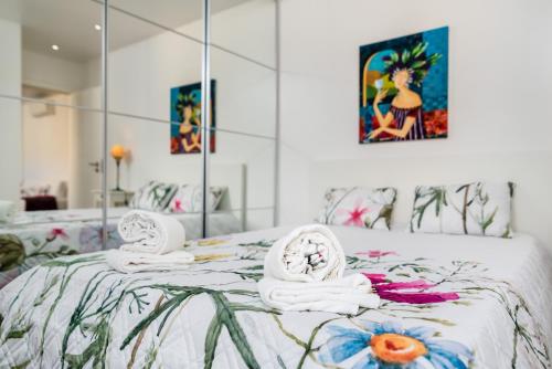 a bedroom with a bed with towels and a mirror at Tilias Apartment at Estoril in Estoril