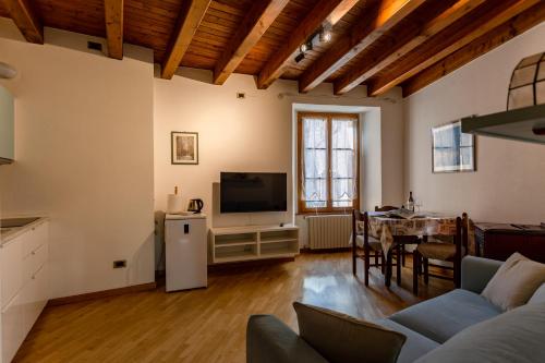 a living room with a couch and a tv and a table at Appartamento Sant'Agostino in Tirano
