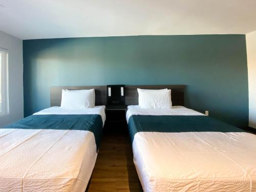 two beds sitting next to each other in a room at Studio 6 Suites Stockton, CA Waterfront in Stockton