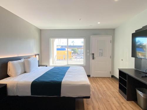 a bedroom with a large bed and a television at Studio 6 Suites Stockton, CA Waterfront in Stockton