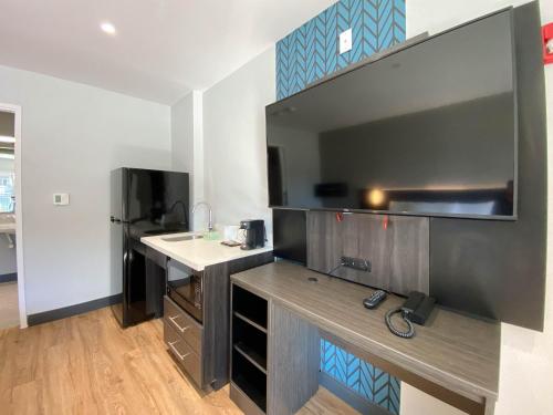 a small kitchen with a counter and a refrigerator at Studio 6 Suites Stockton, CA Waterfront in Stockton