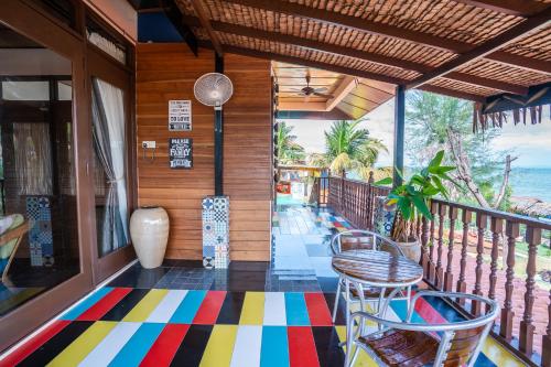 een veranda met stoelen en een kleurrijke vloer bij Lost Paradise Resort in Batu Ferringhi