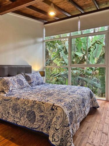 a bedroom with a bed and a large window at Finca Turística de Alojamiento Rural Avalon in Jardin