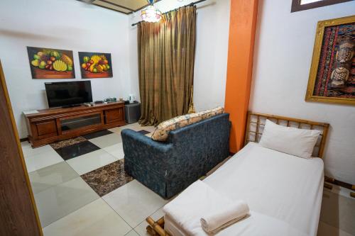 a living room with a couch and a television at Lost Paradise Resort in Batu Ferringhi