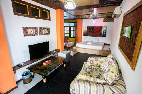 a living room filled with furniture and a fire place at Lost Paradise Resort in Batu Ferringhi