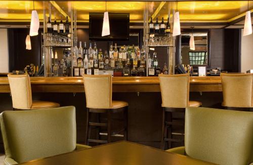 a bar with chairs and a counter with a bar at Sonesta Hotel Gwinnett Place Atlanta in Duluth