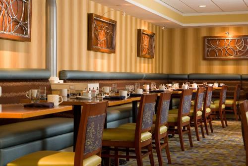 a dining room with wooden tables and chairs at Sonesta Hotel Gwinnett Place Atlanta in Duluth