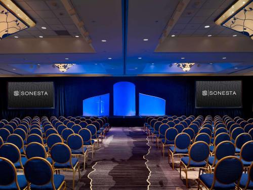 a conference room with blue chairs and screens at Sonesta Hotel Gwinnett Place Atlanta in Duluth