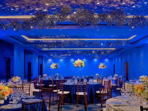 a banquet hall with tables and chairs in a blue room at Sonesta Bee Cave Austin Hill Country in Bee Cave