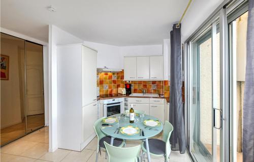 une petite cuisine avec une table et des chaises dans l'établissement Amazing Apartment In Le Barcarès, au Barcarès