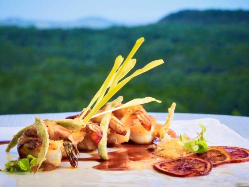 a white plate of food with shrimp and vegetables at Sonesta Bee Cave Austin Hill Country in Bee Cave