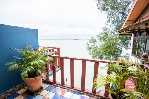 a balcony with potted plants on a house at Lost Paradise Resort in Batu Ferringhi