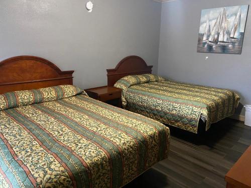 Habitación de hotel con 2 camas y una foto en la pared en Surf Motel and Apartments en Galveston