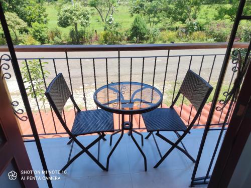 a patio table and two chairs on a balcony at Casa Hotel Victoria Real in Mariquita