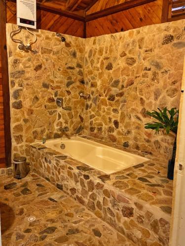a stone bathroom with a bath tub in a stone wall at Finca Turística de Alojamiento Rural Avalon in Jardin