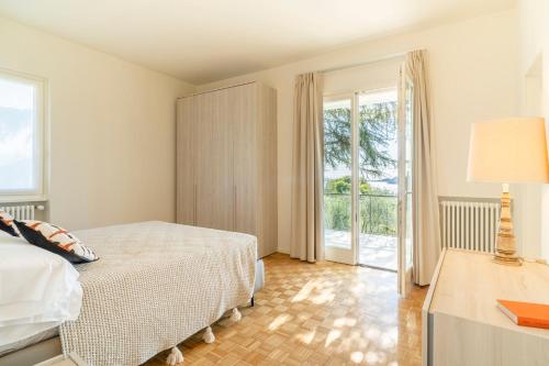 a bedroom with a bed and a table with a lamp at Villa dei Lauri - villa vista lago con piscina in Salò