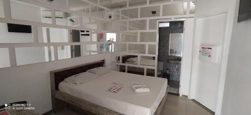 1 dormitorio con 1 cama con paredes y estanterías blancas en Motel Flex Love (Adults Only), en Aracaju