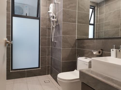 une salle de bain avec toilettes, lavabo et miroir dans l'établissement Bell Family Suite @Sepang Kota Warisan KLIA, à Sepang