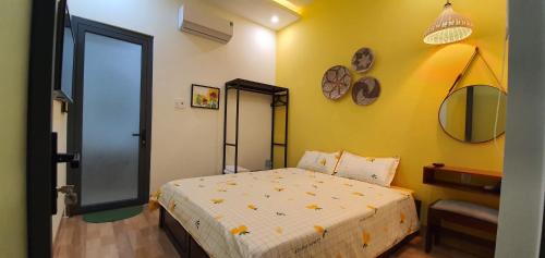 a bedroom with a bed and a yellow wall at Sun&Sea House Homestay in Quy Nhon