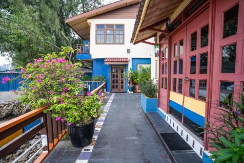 a colorful house with flowers on the sidewalk at Lost Paradise Resort in Batu Ferringhi