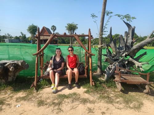 two people sitting on a bench at a park at Kakrona Pouk Homestay in Siem Reap
