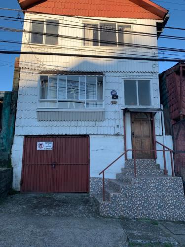 a house with a red door and a garage at Hospedaje Familiar Glady's House in Puerto Montt