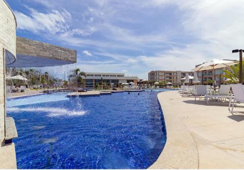 a swimming pool with a fountain in a resort at Muro alto Flat Porto de Galinhas in Porto De Galinhas
