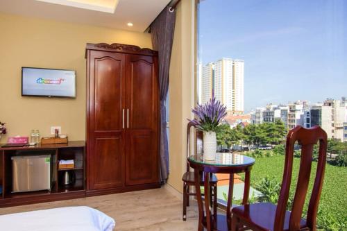 een kamer met een tafel en een groot raam bij Sea Memory Hotel in Vung Tau