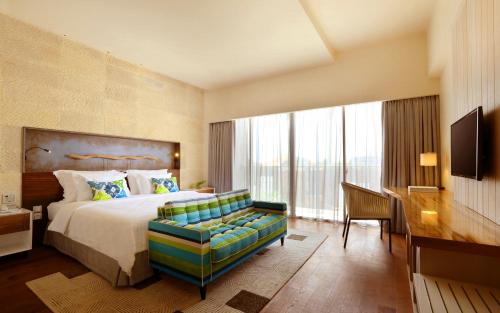 une chambre d'hôtel avec un lit et un canapé dans l'établissement TS SUITES Seminyak Bali, à Legian