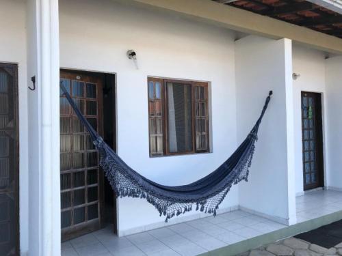a hammock hanging on the side of a building at 250m da praia-Kitinete com Piscina-Matinhos-PR in Matinhos
