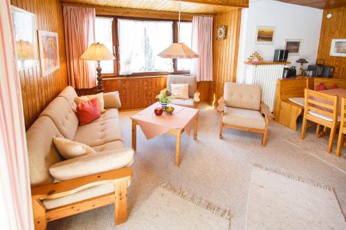 een woonkamer met een bank en een tafel bij Am Traunufer Anneliese Plenk inkl. Chiemgaukarte in Ruhpolding