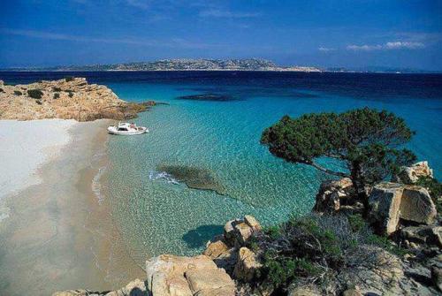 a boat in the water on a beach at Bed and Breakfast Su Niu in Quartucciu