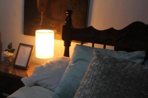 a bedroom with a bed with a lamp on a table at Casa de hospedaje Vivaio in Paipa