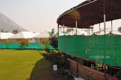 a view of a building with a green fence at Shivir Aranya - Wilderness Resort in Alwar