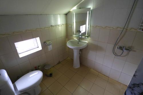 La salle de bains est pourvue d'un lavabo, de toilettes et d'une douche. dans l'établissement Даунтаун Велико Търново, à Veliko Tarnovo