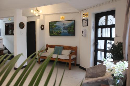 una sala de estar con sofá y una pintura en la pared en Casa de hospedaje Vivaio, en Paipa
