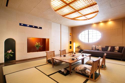 a living room with a table and a couch at Honjin Hiranoya Kachoan in Takayama