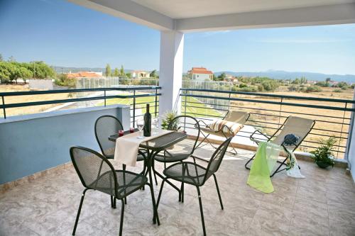 a patio with a table and chairs on a balcony at Aeolian Gaea Hotel in Skala Kallonis