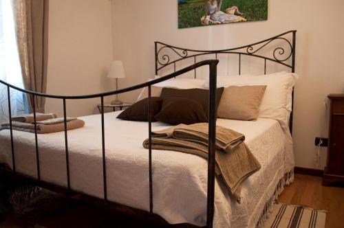 1 dormitorio con cama de metal negro con sábanas blancas en Di-vinodormire, en La Morra