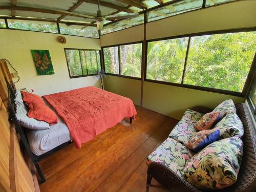 a bedroom in a house with a bed and a couch at Cabina Gan Eden - Walking distance from river in Portalón