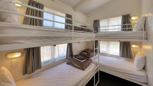two bunk beds in a room with windows at Lake Boga Caravan Park in Lake Boga