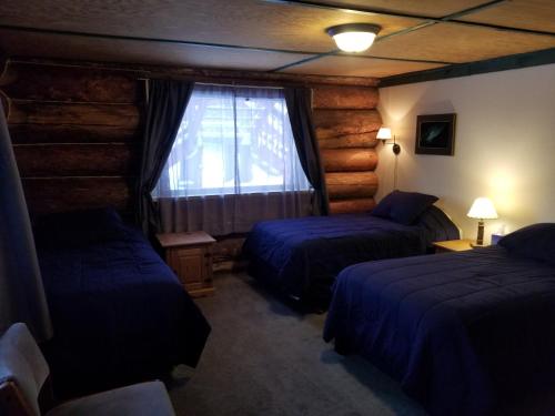 a hotel room with two beds and a window at Northern Sky Lodge in Fairbanks