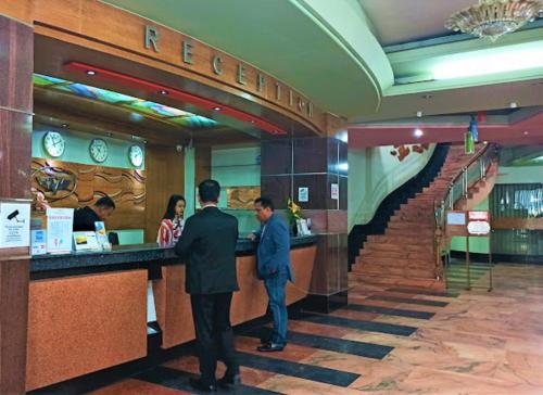 two men standing at a bar in a restaurant at Hotel Victory - Best in City Center in Dhaka