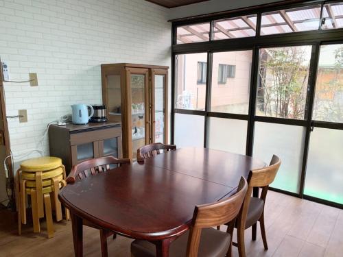 a dining room with a wooden table and chairs at ペットOk小田原箱根駅伝が見られる家 in Sakawa