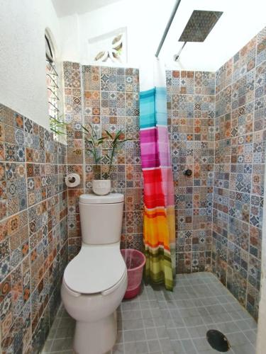 a bathroom with a toilet and a colorful shower at Casa de Huespedes Cielito Lindo in Santa Cruz Huatulco